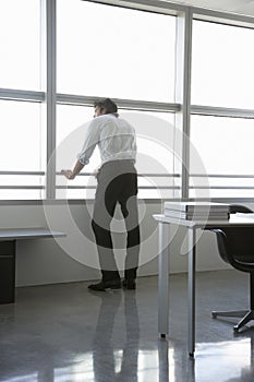 Businessman Looking Out Of Office Window