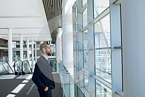 Businessman looking out of window in office lobby