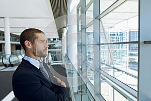 Businessman looking out of window in office lobby