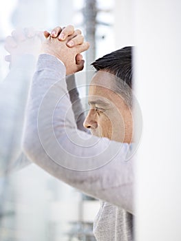 Businessman looking out window thinking