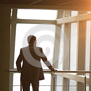 Businessman looking out the window thinking about business ideas