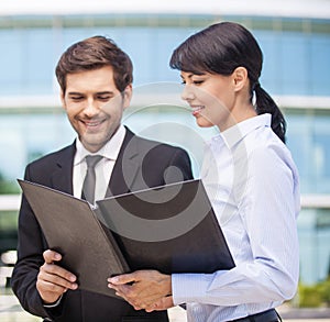 Businessman looking at paperwork with businesswoman.