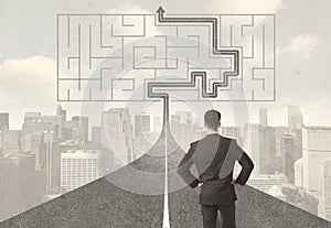 Businessman looking at road with maze and solution