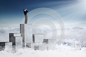 Businessman looking at sky with binoculars