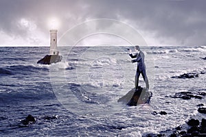 Businessman looking through a telescope against stormy sea with lighthouse