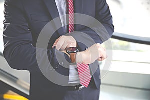 Businessman looking at the time on his wrist watch