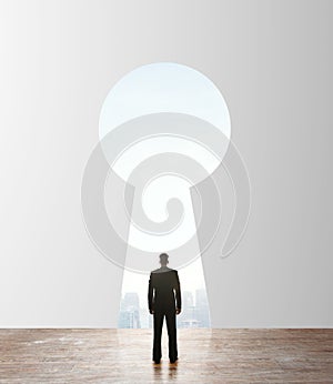 Businessman looking to keyhole