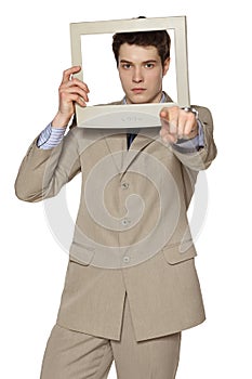 Businessman looking through the TV / computer screen pointing at camera