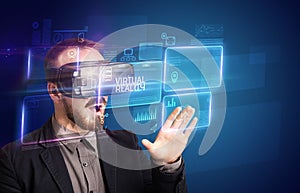 Businessman looking through Virtual Reality glasses, tech concept