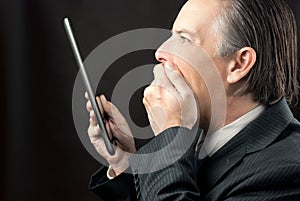 Businessman Looks At His Tablet Amazed