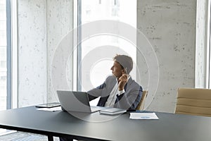 Businessman looks out window at city view seated at workplace