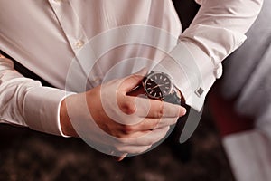 businessman looks at the watch on his wrist, looks at the time. High quality photo