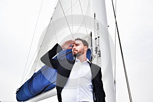 Businessman on luxury yacht, handsome man wearing white shirt and suit on boat