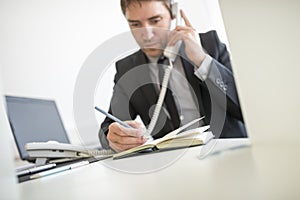 Businessman making a note in his diary