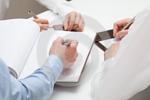 Businessman making notes in a datebook