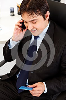 Businessman making purchase by phone and ca