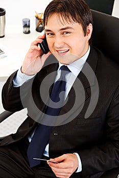 Businessman making purchase by phone and card