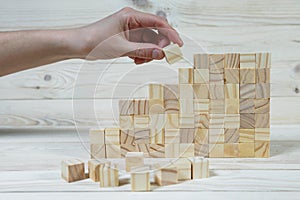 Businessman making a pyramid with empty wooden cubes