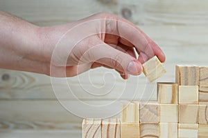 businessman making a pyramid with empty wooden cubes