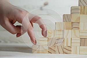 businessman making a pyramid with empty wooden cubes