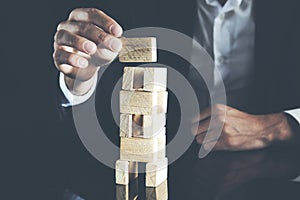 Businessman making a pyramid with empty wooden cubes