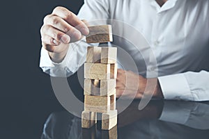 Businessman making a pyramid with empty wooden cubes