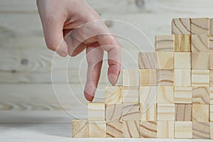 Businessman making a pyramid with empty wooden cubes