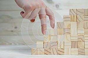 Businessman making a pyramid with empty wooden cubes