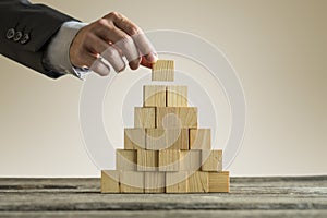 Businessman making a pyramid with empty wooden cubes