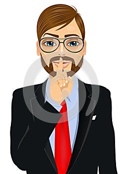 Businessman making silence or secret hand gesture