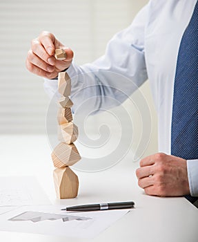 Businessman making tower of wooden blocks