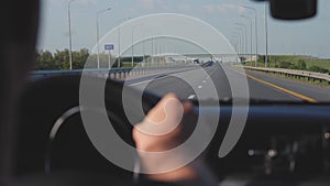 Businessman man driving a car, hand on the steering wheel, looking forward to the road