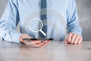 Businessman, man hold in hand magnifying glass icon.business, technology and internet concept