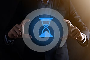 Businessman man holds in hand hourglasses icon. Time expires. A reminder to action. Business concept. Elements for design