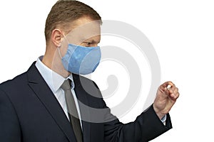 Businessman man in a medical mask looks at a thermometer.