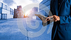 Businessman manager using tablet standing with cargo containers background