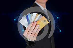 Businessman with many credit cards as the power to spend on world map background in your hands concept
