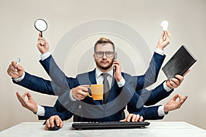 Businessman with many hands in a suit. Works simultaneously with several objects, a mug, a magnifying glass, papers, a contract, a