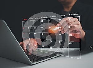 Businessman marking dates on virtual calendar, managing his business schedule, setting reminders for important appointments,