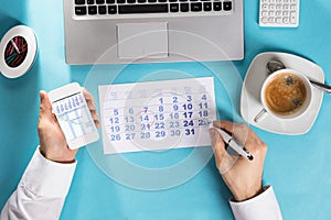 Businessman Marking Schedule On Calendar Using Gantt Chart