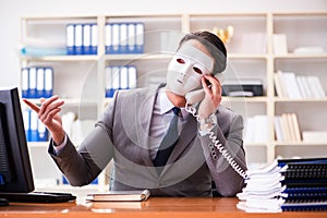 The businessman with mask in office hypocrisy concept photo