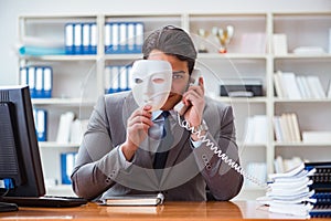 The businessman with mask in office hypocrisy concept photo