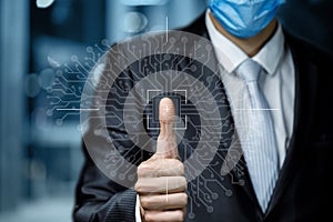 Businessman in a mask scans a fingerprint on a blurred background