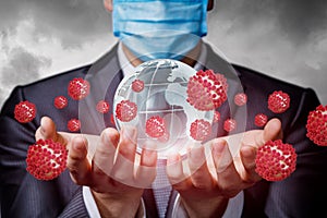 A businessman in a mask supports a globe infected by the coronavirus