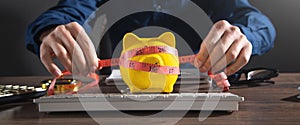 Businessman measuring piggy bank with measuring tape