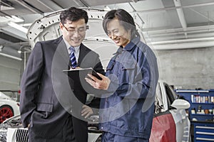 Businessman with Mechanic in Auto Repair Shop