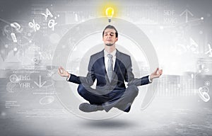 Businessman meditates with enlightenment concept