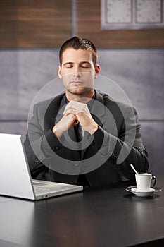 Businessman meditating at desk