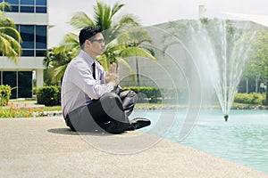 Businessman Meditating Doing Yoga Outside Office Building