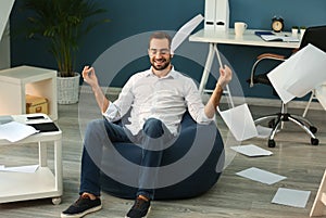 Businessman meditating with a lot of work in office